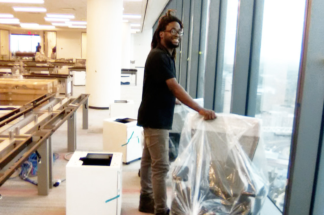 African American man smiling during furniture installation project